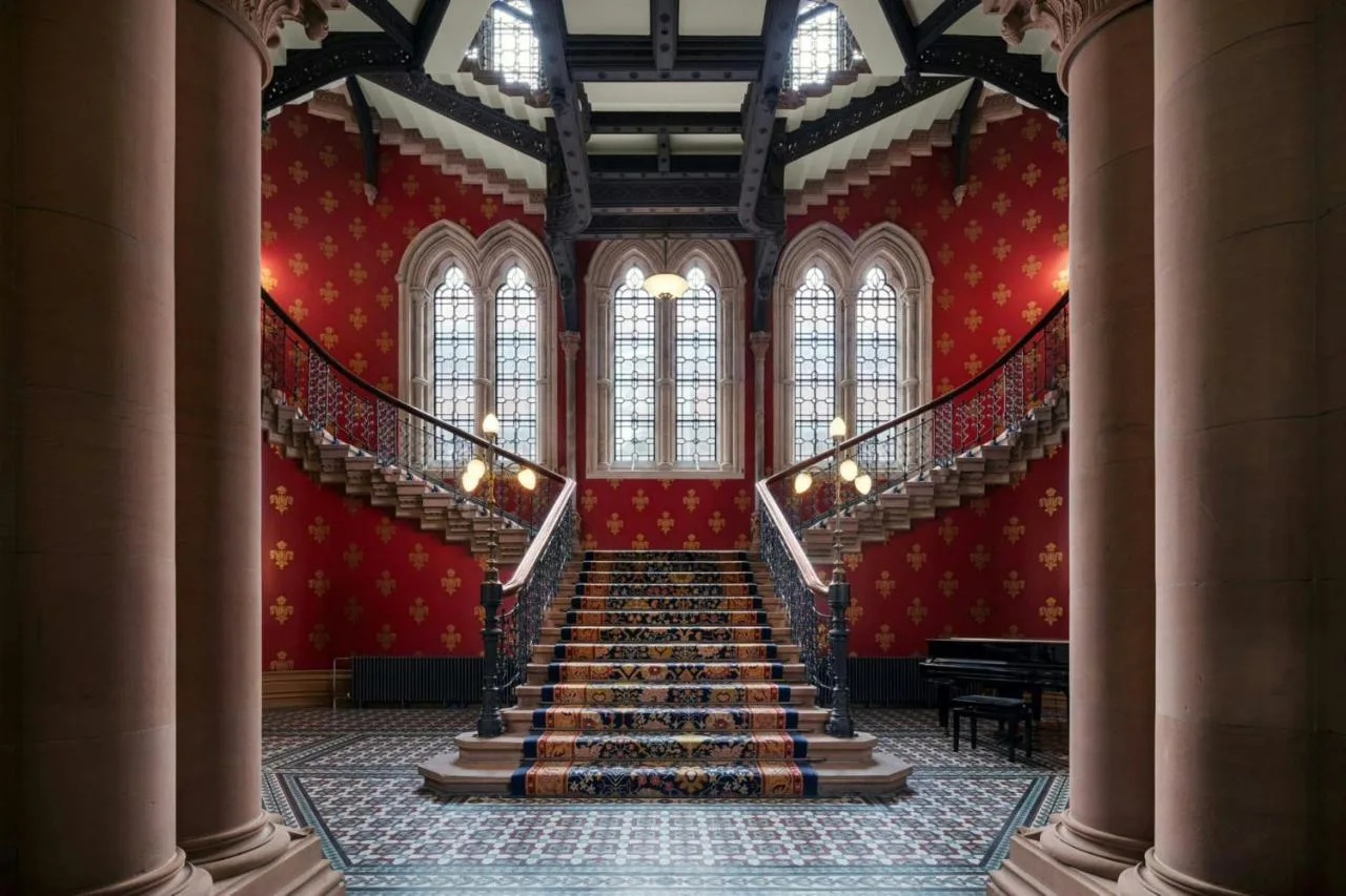 a staircase in a building with red walls and windows at St Pancras London, Autograph Collection