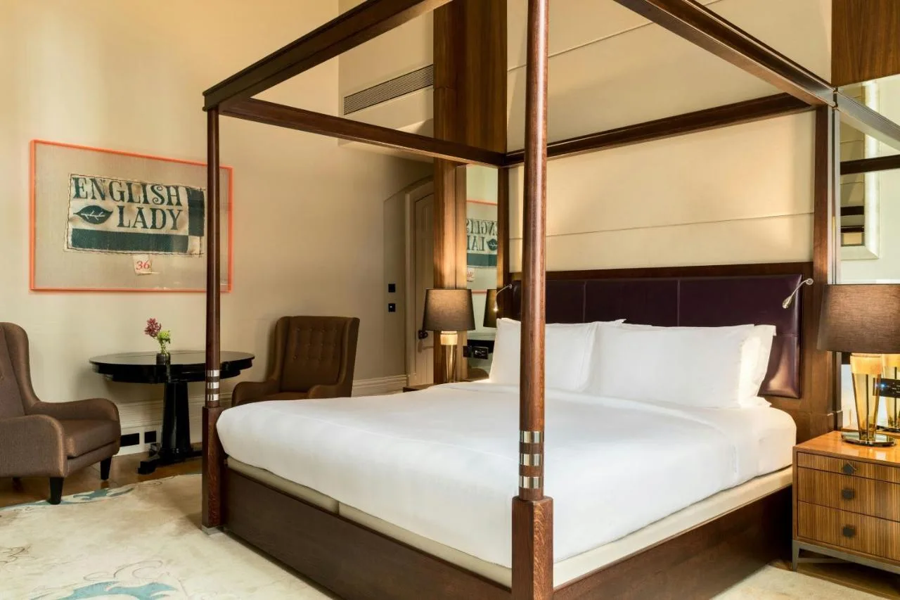 a bedroom with a canopy bed and a desk at St Pancras London, Autograph Collection