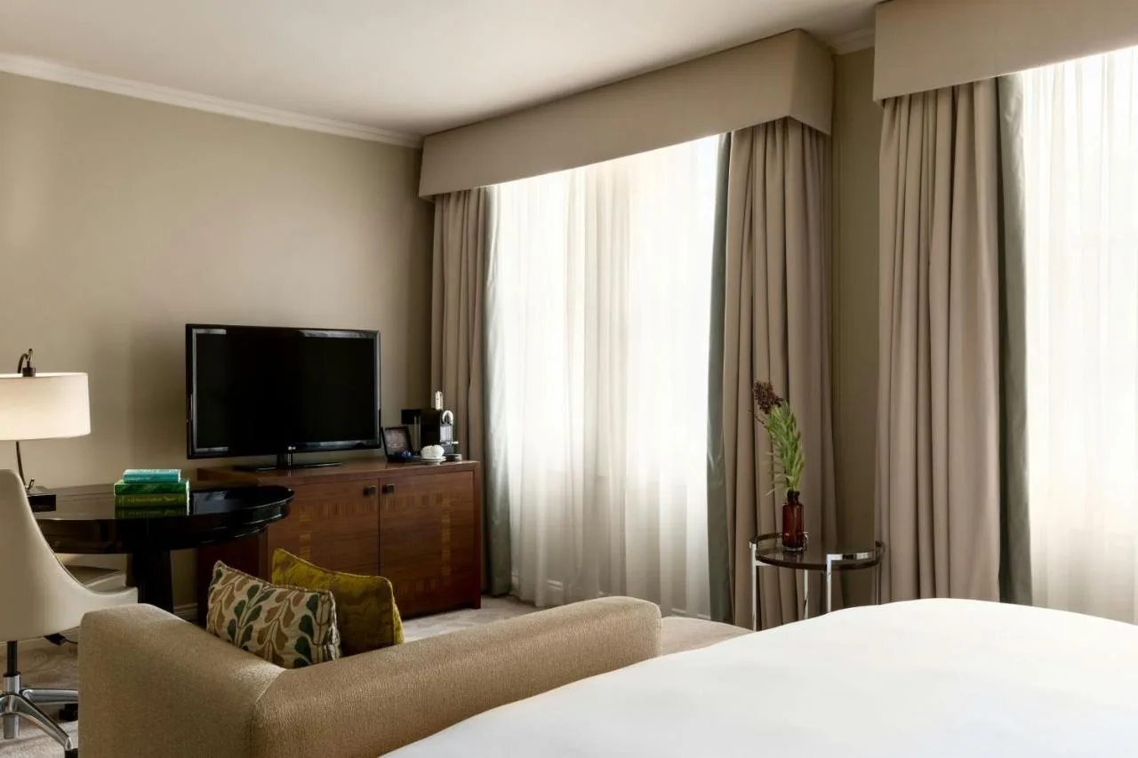a hotel room with a bed and a flat screen tv at St Pancras London, Autograph Collection
